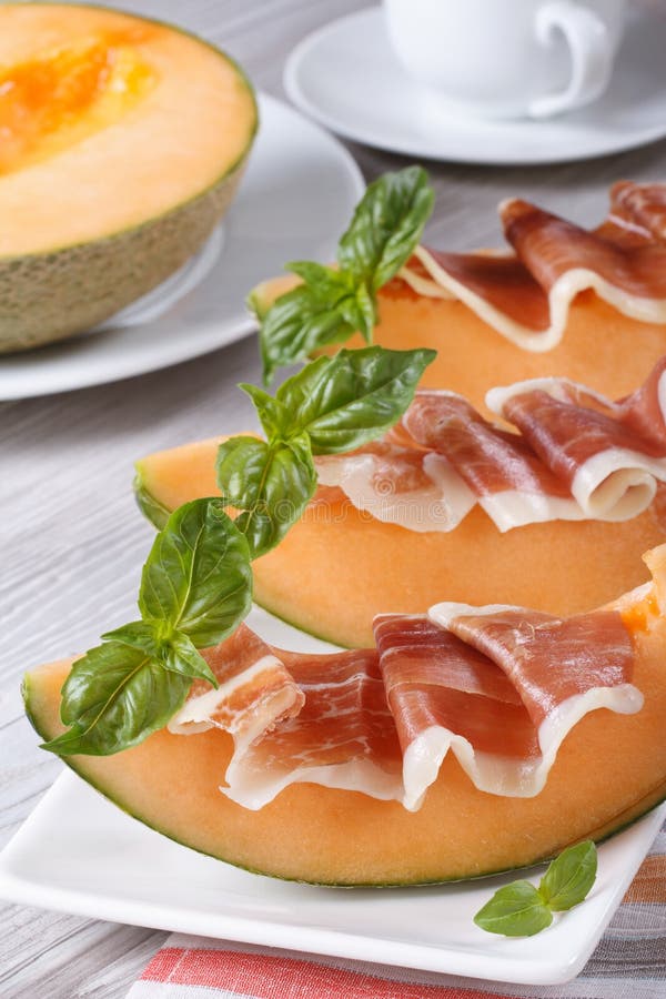 Italian Appetizer Melon with Ham on Skewers Vertical Stock Photo