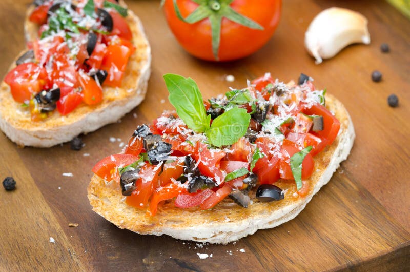 Italian bruschetta with tomato, olives, basil and cheese horizon