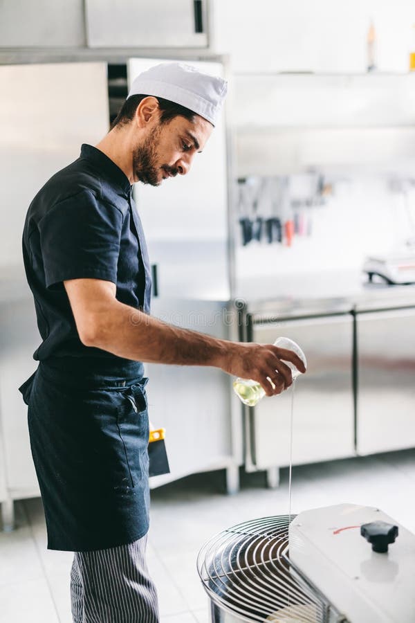 Italian Chef Pizzaiolo Preparing Pizza Dough in Restaurant Kitchen