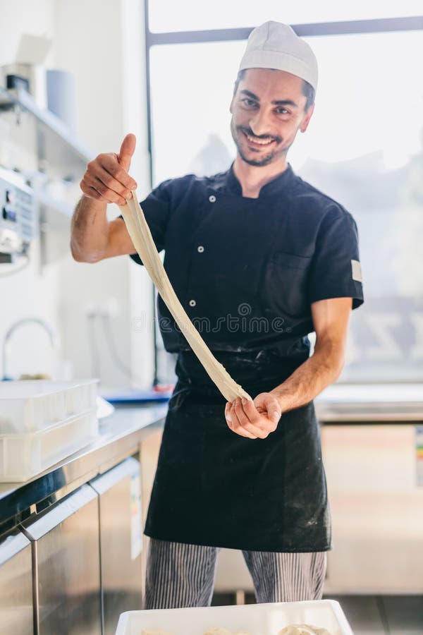 Italian Chef Pizzaiolo Preparing Pizza Dough in Restaurant Kitchen