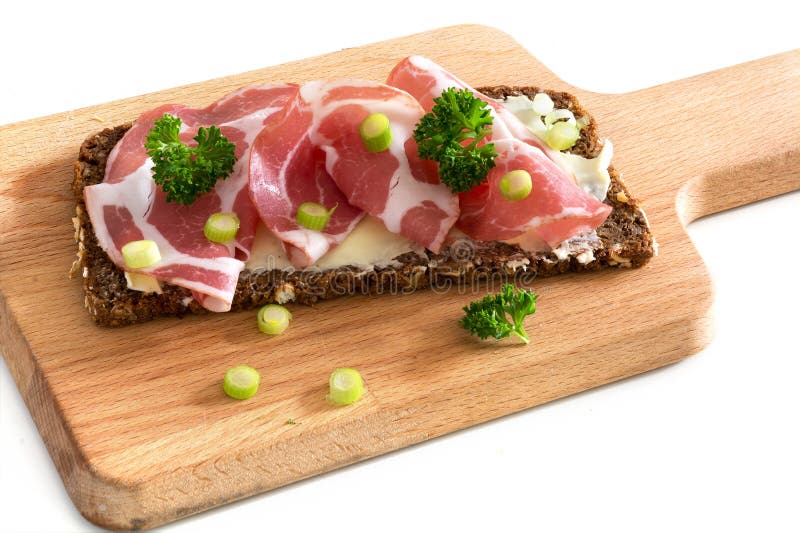 Italian Coppa Or Capicola Ham On Dark Bread On A Wooden Cutting Stock