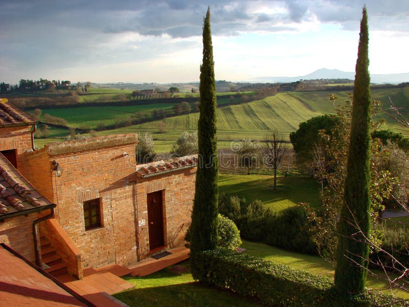 Una tipica villa di campagna in Toscana con un bel paesaggio sullo sfondo.