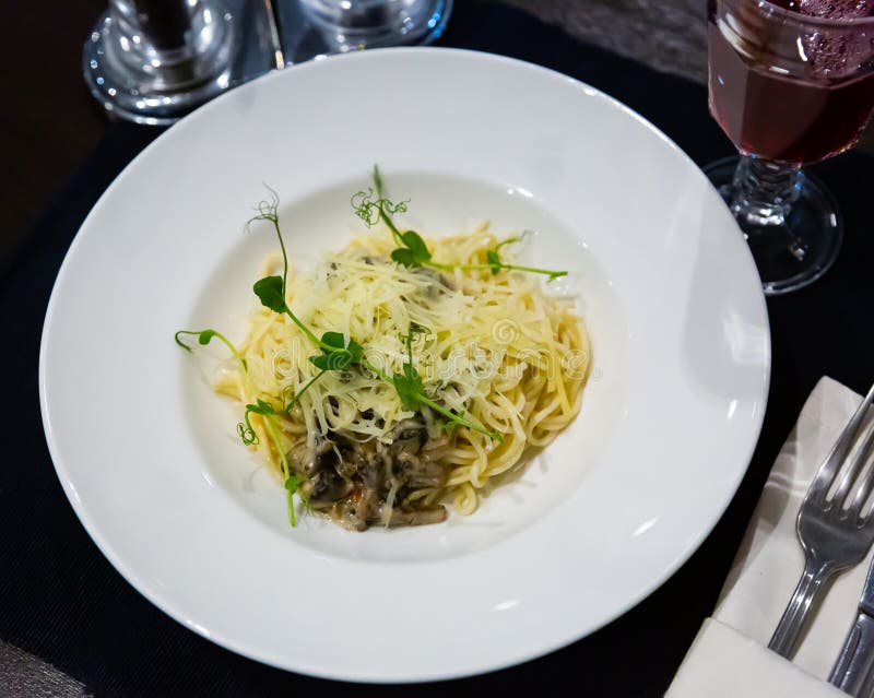 Italian Creamy Mushroom Pasta with Cheese Garnished with Microgreens