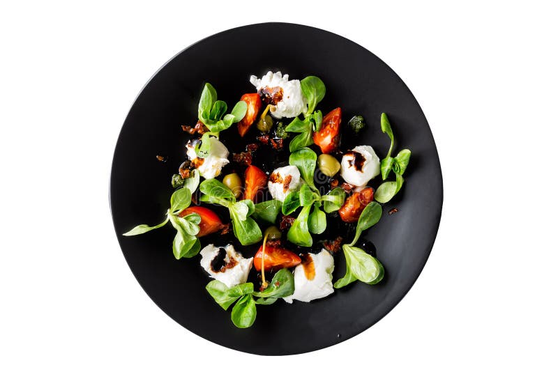 Italian cuisine. Fresh italian caprese salad with mozzarella and tomatoes on dark plate isolated on white background. Top view