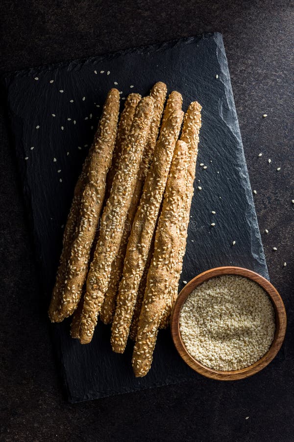 Italian Grissini Bread Sticks with Sesame Seeds on Black Table. Top