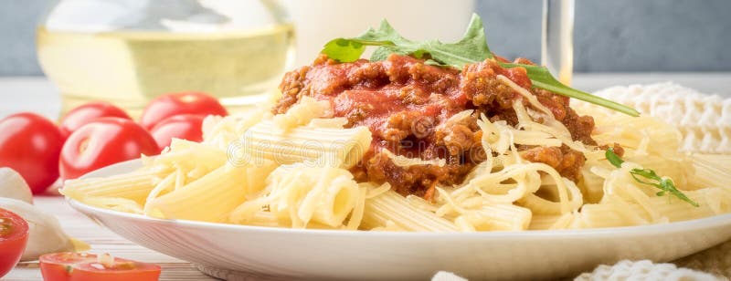 Italian pasta bolognese from pasta penne rigatone minced meat in tomato sauce and parmesan cheese