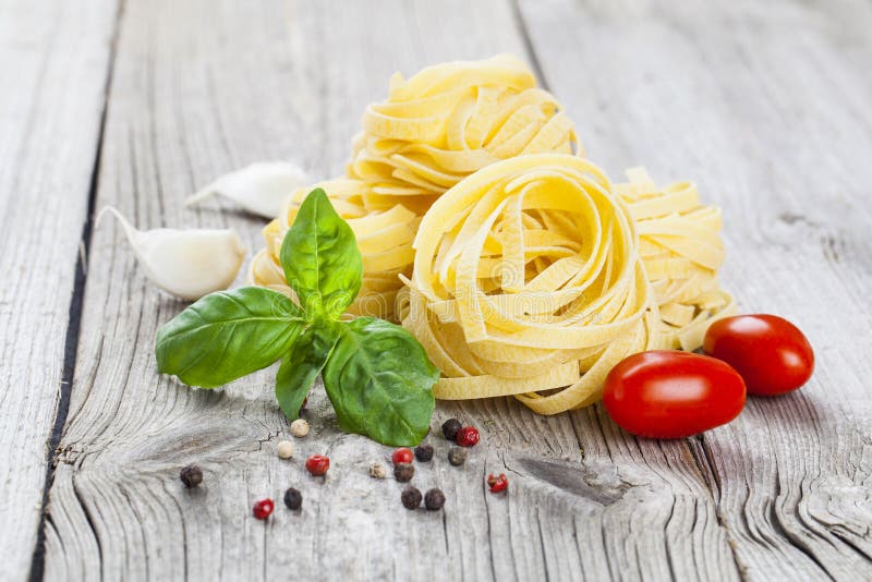 Italian pasta fettuccine nest with garlic, tomatoes basil stock photo Italian pasta fettuccine nest with garlic, tomatoes basil stock photo
