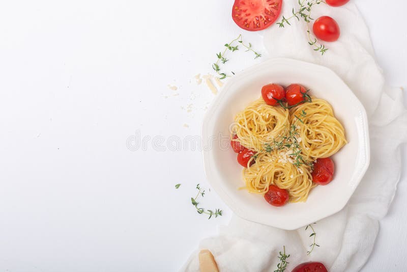 Italian pasta spaghetti with fried cherry tomato and thyme, close up shot with copy space