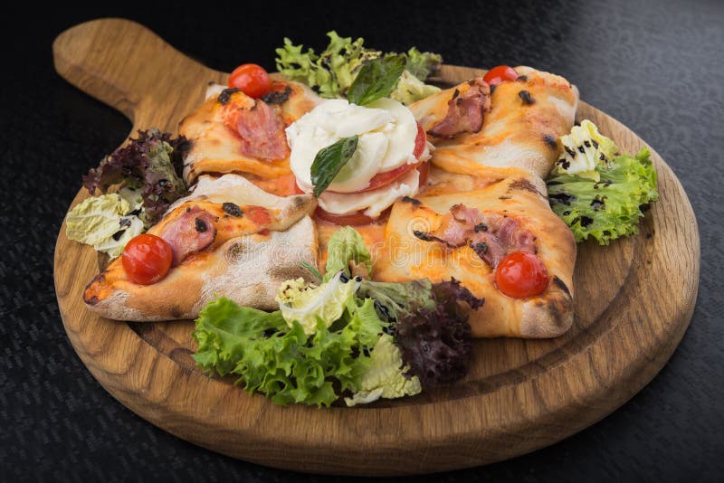 Italian pizza calzone with tomato, salad and mozzarella