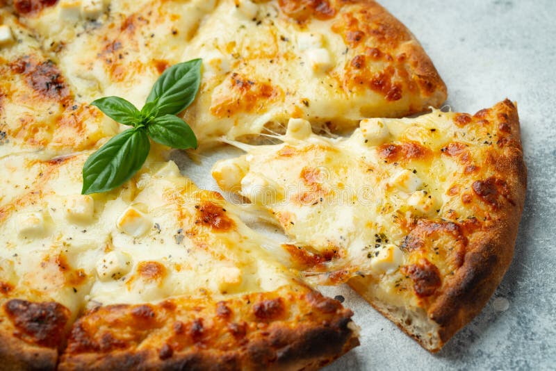 Italian Pizza Four Cheeses with Stretching Cheese and Basil on a Light