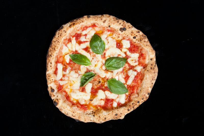 Real Italian Margherita Pizza just cooked mozzarella tomato and basil on a black background from the top stock photo