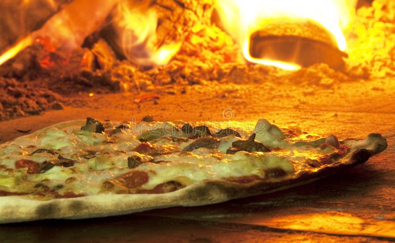 Italian pizza in a wood burning oven stock image