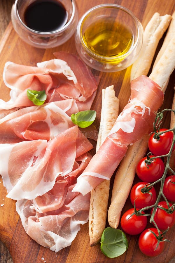Italian prosciutto ham grissini bread sticks tomato olive oil royalty free stock photography Italian prosciutto ham grissini bread sticks tomato olive oil royalty free stock photography