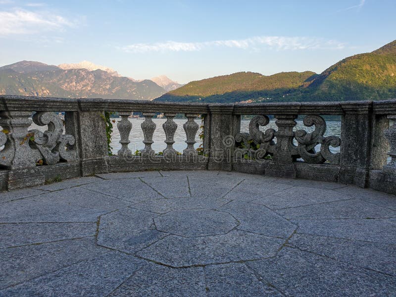 Italian stone balustrade illuminated by sun rays and water in the background