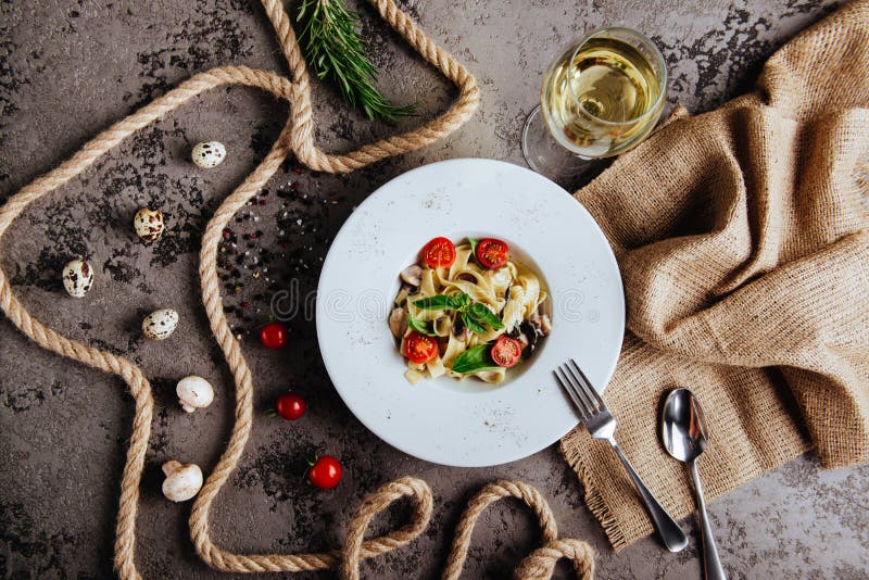 Italian style pasta dinner. Spaghetti with tomato and basil in plate on wooden board stock image Italian style pasta dinner. Spaghetti with tomato and basil in plate on wooden board stock image