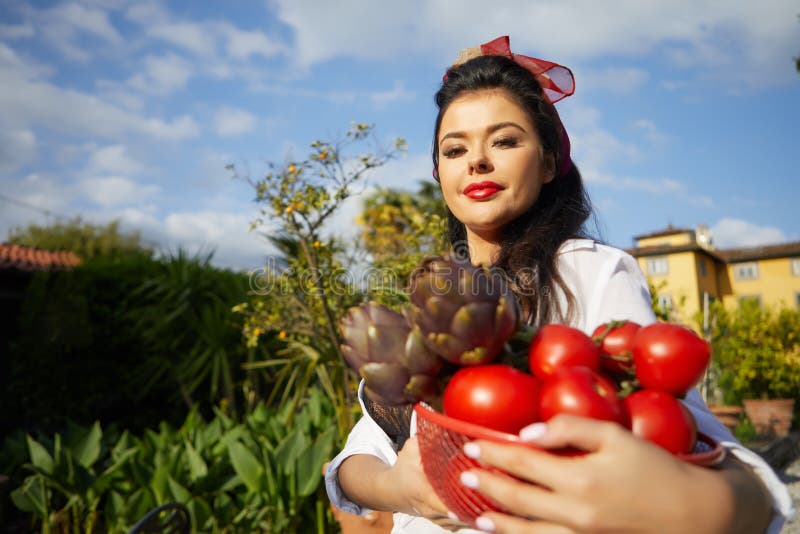 An Italian woman, a housewife, collects vegetables for dinner in a home garden royalty free stock images An Italian woman, a housewife, collects vegetables for dinner in a home garden royalty free stock images