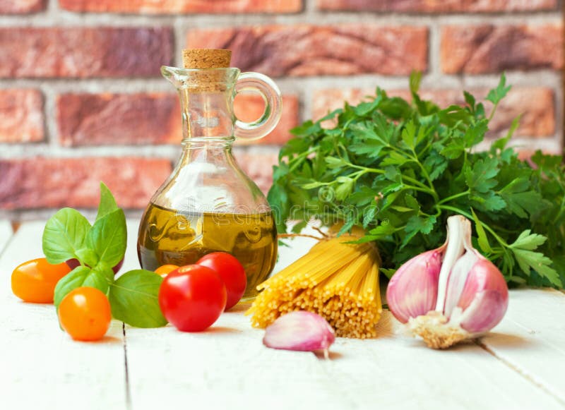 Italienische mediterrane Küche Zutaten extra natives Olivenöl in Glasflasche Bundle Spaghetti gelbe rote Kirschtomaten stockfotos Italienische mediterrane Küche Zutaten extra natives Olivenöl in Glasflasche Bundle Spaghetti gelbe rote Kirschtomaten stockfotos