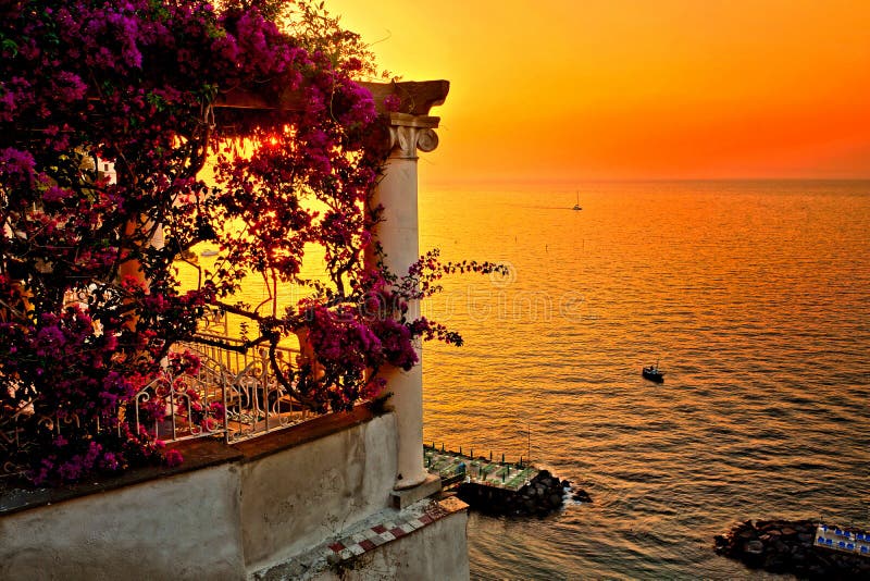 Italiensk kustsolnedgång från en blomma fylld terrass som förbiser medelhavet i Sorrento royaltyfri fotografi