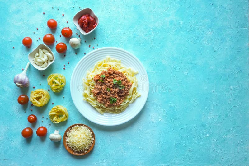 Italiensk pasta med bolognese sås Grönsaker på den blåa tabellen royaltyfria foton Italiensk pasta med bolognese sås Grönsaker på den blåa tabellen royaltyfria foton