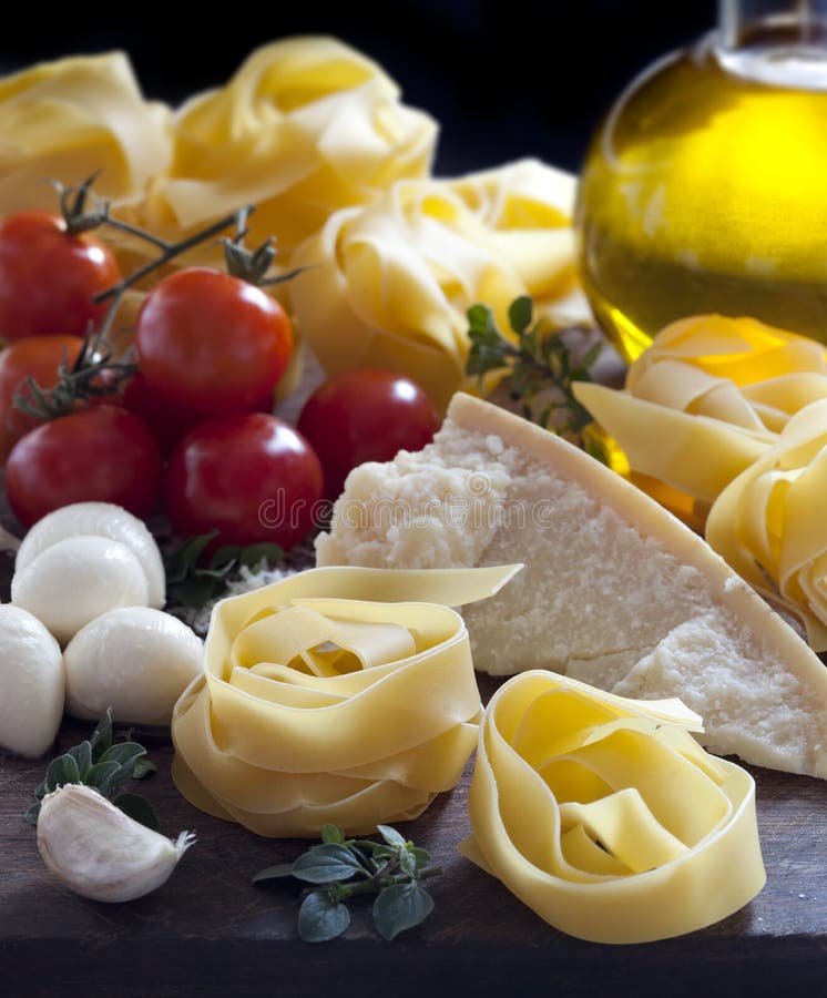 Italian food ingredients, including pasta, mozzarella, tomatoes, parmesan, olive oil, garlic and herbs. Lovely pappardelle in the making. Italian food ingredients, including pasta, mozzarella, tomatoes, parmesan, olive oil, garlic and herbs. Lovely pappardelle in the making.