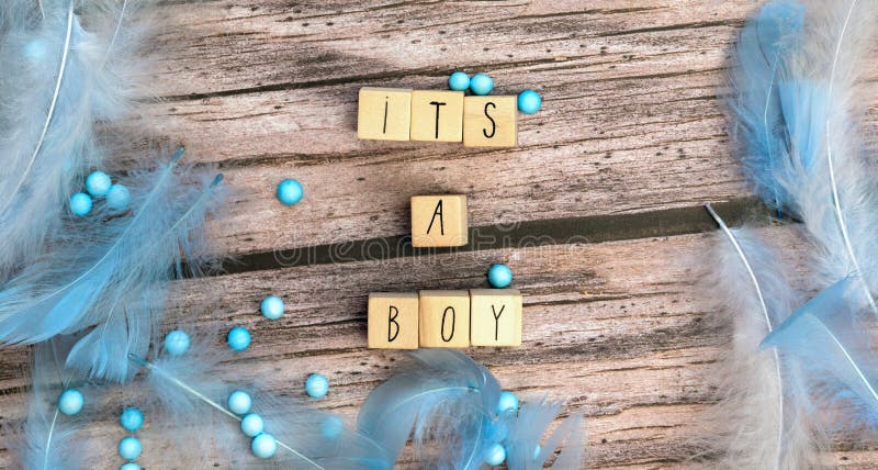 Its a boy text on wooden background texture with blue feathers for baby invitation shower or newborn, boy announcement greeting card, top view colorful blue design