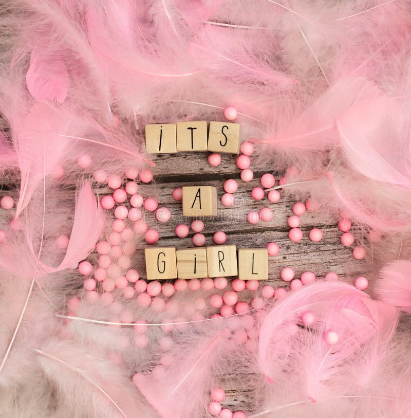 Its a Girl text on wooden background texture with pink feathers for baby invitation shower or newborn, girl announcement greeting card, top view colorful design pastel colors