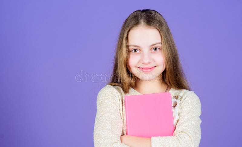 Its her favorite book. Cute small child with text book in hands. Adorable little girl holding exercise book. Self study