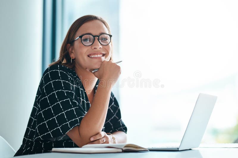 Its a lightbulb moment. Cropped portrait of a happy young businesswoman working on a laptop in an office.