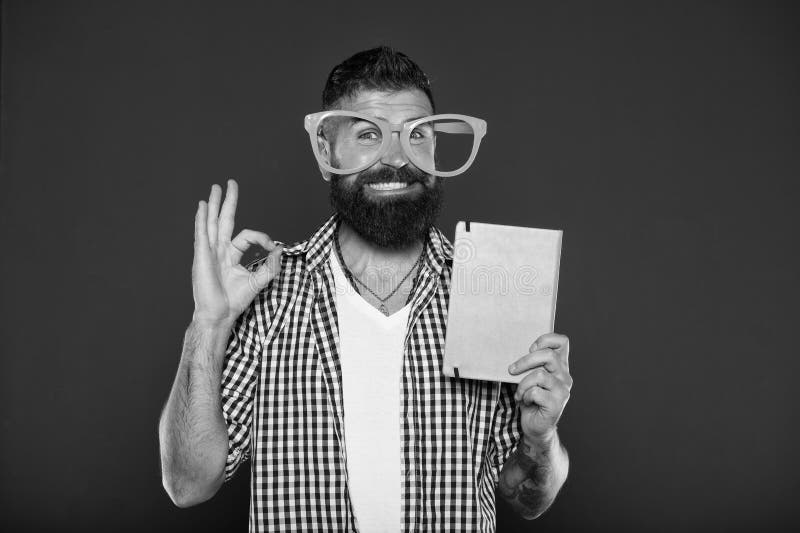 Its ok. Study nerd inviting for reading book. University male student with lecture notes. Bearded man in party glasses royalty free stock image Its ok. Study nerd inviting for reading book. University male student with lecture notes. Bearded man in party glasses royalty free stock image