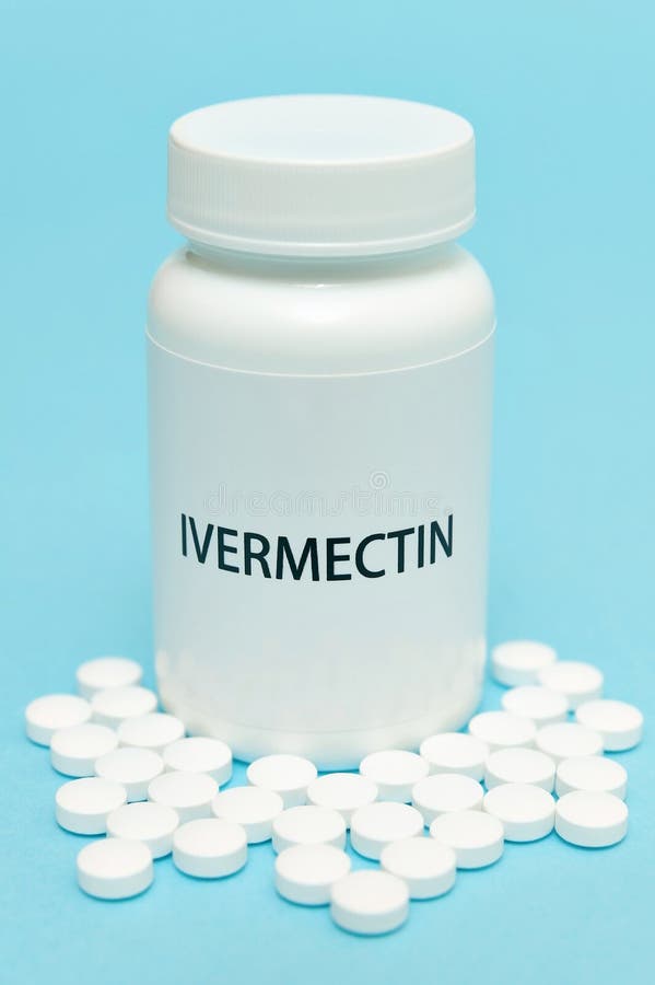 IVERMECTIN in white bottle packaging with scattered pills. Isolated on blue background. Treatments for Coronavirus COVID-19