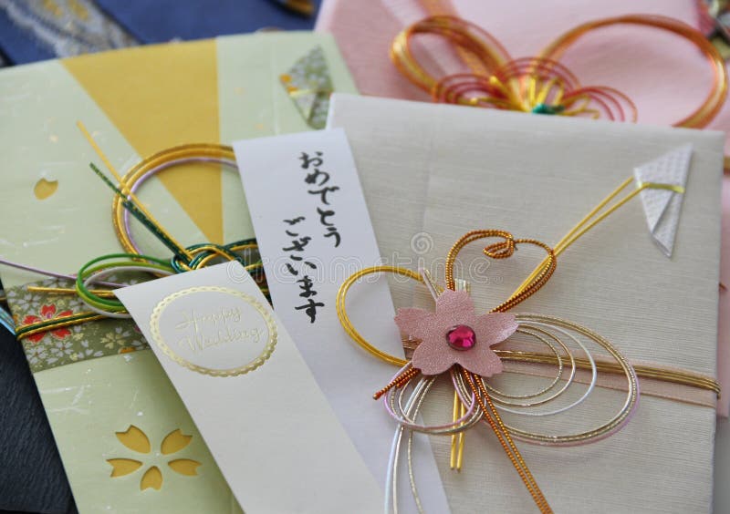 An ivory embellished Japanese money envelope with strips of paper saying Happy Wedding and Omedetou gozaimasu (congratulations). An ivory embellished Japanese money envelope with strips of paper saying Happy Wedding and Omedetou gozaimasu (congratulations).