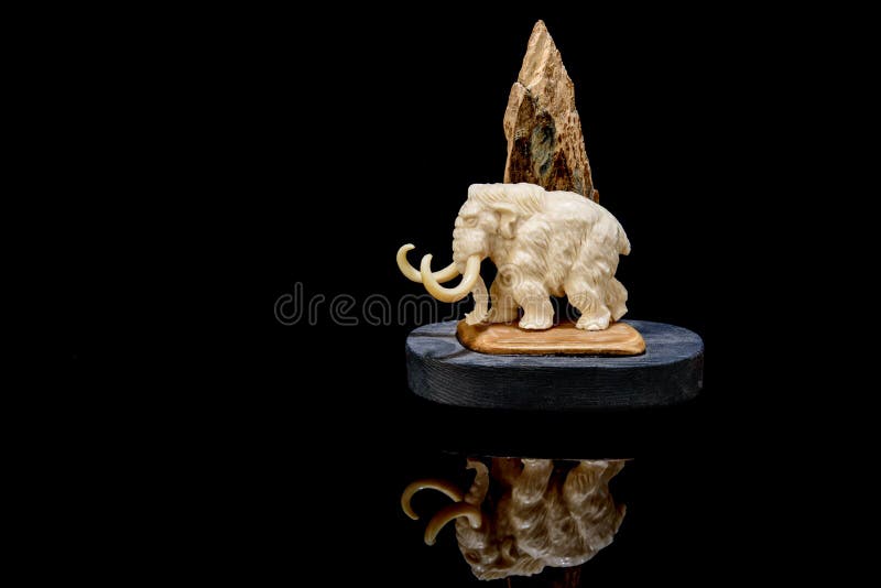 ivory statuette of elephant mammoth on black background