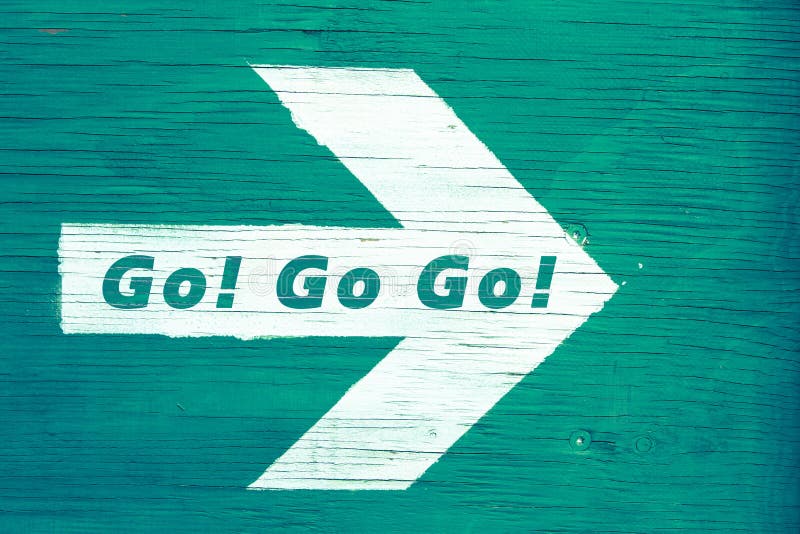 `Go! Go! Go!` text written on a white directional arrow pointing towards right manually painted on a green blueish wooden signboard background. Photo framed horizontally. `Go! Go! Go!` text written on a white directional arrow pointing towards right manually painted on a green blueish wooden signboard background. Photo framed horizontally.