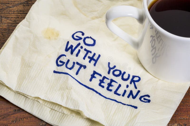 Go with your gut feeling - advice or motivational reminder on a napkin with cup of espresso coffee. Go with your gut feeling - advice or motivational reminder on a napkin with cup of espresso coffee