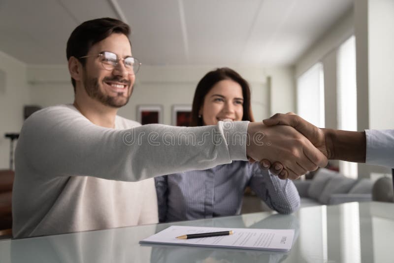 J'ai serré la main millénaires satisfaisants de sourire d'homme à l'agent d'assurance photos libres de droits