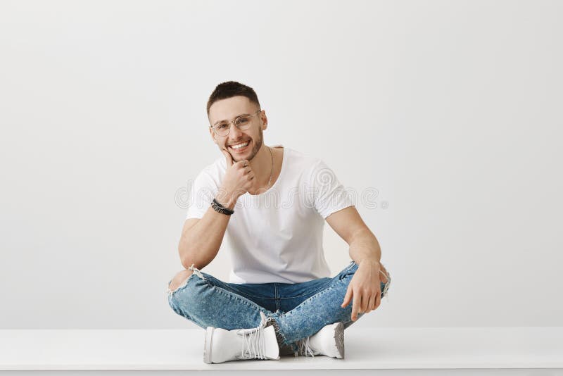 J'aime écoute vos histoires Tir d'intérieur de jeune homme beau avec le poil se reposant sur le plancher avec les jambes croisées photo libre de droits J'aime écoute vos histoires Tir d'intérieur de jeune homme beau avec le poil se reposant sur le plancher avec les jambes croisées photo libre de droits