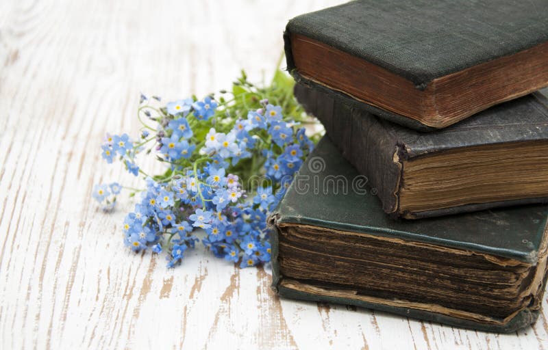 Bunch of forget-me-nots flowers and very old books. Bunch of forget-me-nots flowers and very old books