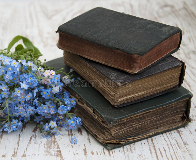 Bunch of forget-me-nots flowers and very old books. Bunch of forget-me-nots flowers and very old books