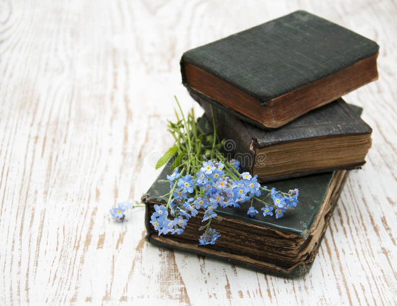 Bunch of forget-me-nots flowers and very old books. Bunch of forget-me-nots flowers and very old books