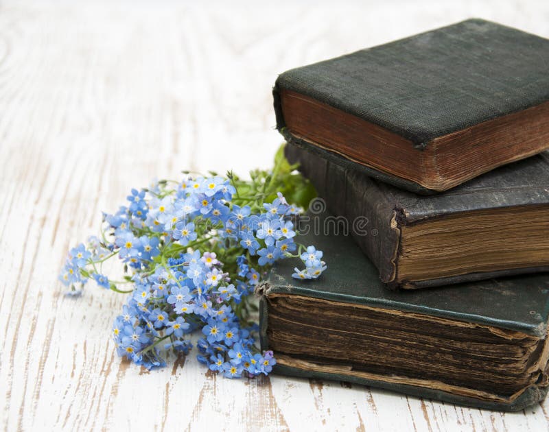 Bunch of forget-me-nots flowers and very old books. Bunch of forget-me-nots flowers and very old books