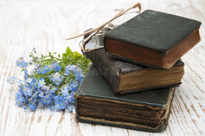 Bunch of forget-me-nots flowers and very old books. Bunch of forget-me-nots flowers and very old books