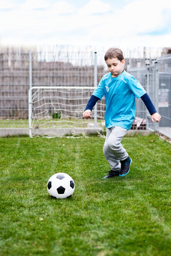 7 jaar jongen het schoppen bal in de tuin stock afbeeldingen 7 jaar jongen het schoppen bal in de tuin stock afbeeldingen