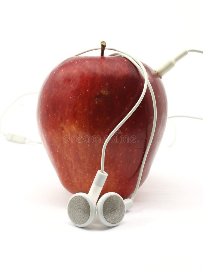 Red Delicious apple wrapped in music earbuds photographed on a white background. Red Delicious apple wrapped in music earbuds photographed on a white background