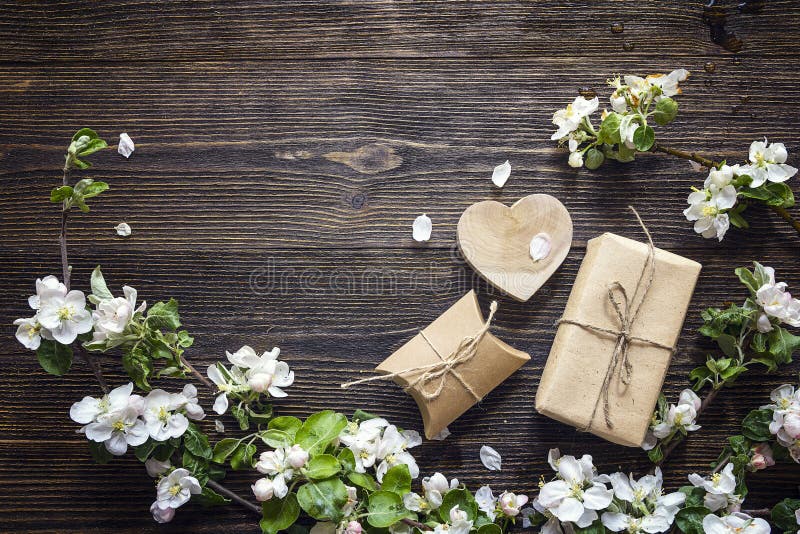 Apple blossom and gift boxes on dark wooden background. Copy space. Top view. Apple blossom and gift boxes on dark wooden background. Copy space. Top view.