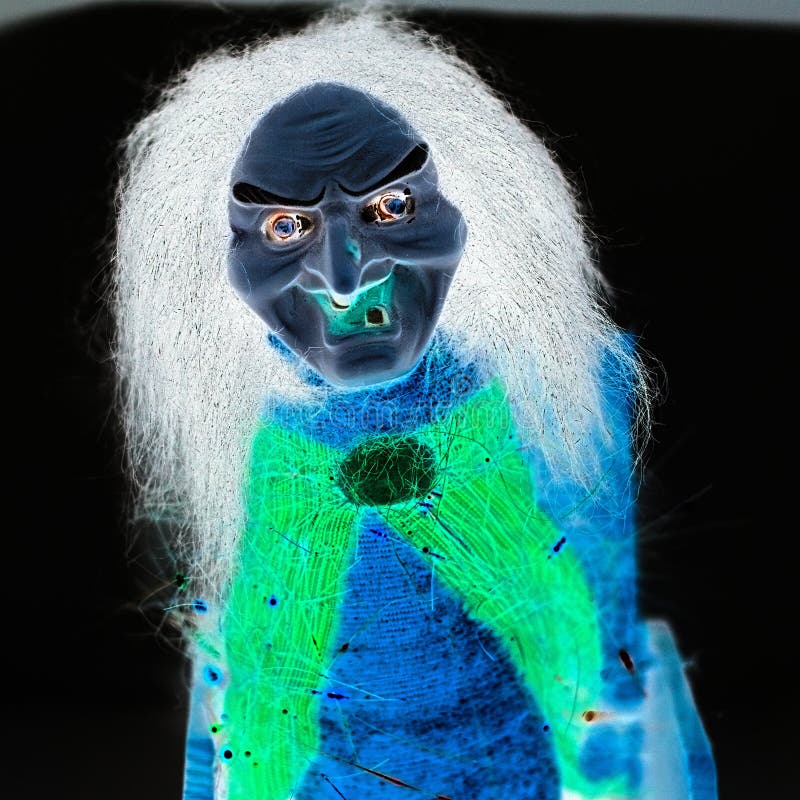 Um troll assustador com olhos verdes e rosto azul está na frente de um  fundo escuro.