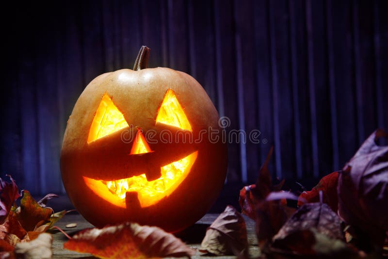 Jack o lanterns Halloween pumpkin face on wooden background