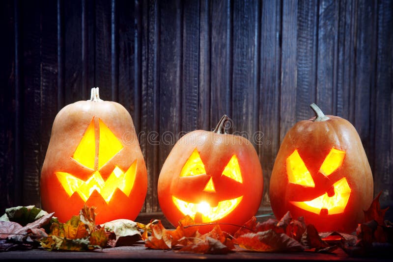 Jack o lanterns Halloween pumpkin face on wooden background