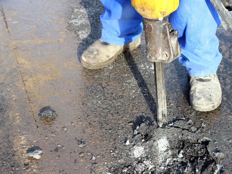 Jackhammer in action in the construction site on the road. Jackhammer in action in the construction site on the road