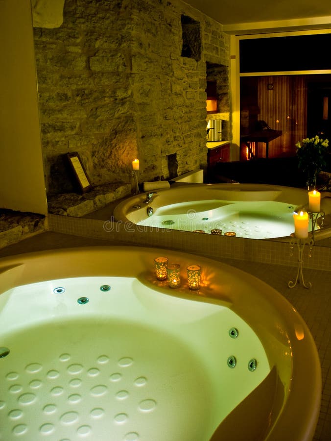 Hotel jacuzzi elegantly lit with candles and green light, sauna reflected in the mirror. Hotel jacuzzi elegantly lit with candles and green light, sauna reflected in the mirror.