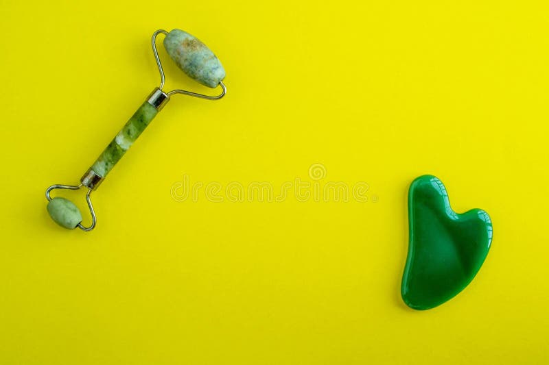 Jade massagers on a yellow background. Background with copy space royalty free stock photography